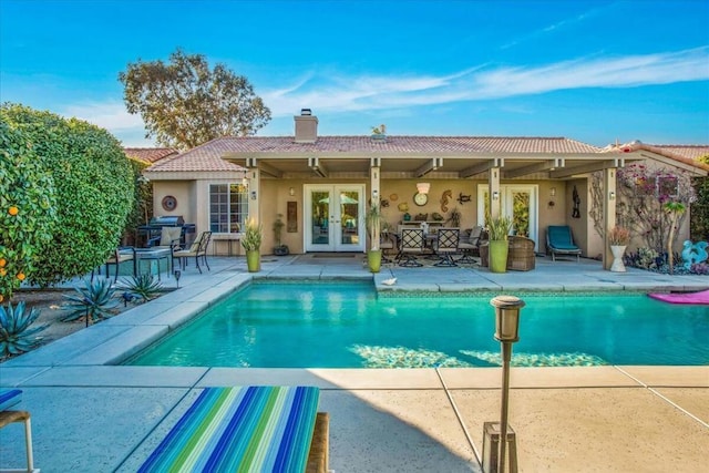 view of pool featuring french doors and a patio area