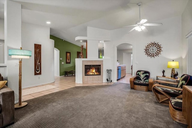 carpeted living room with ceiling fan, a fireplace, and vaulted ceiling