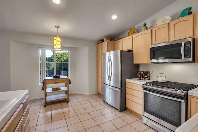 kitchen with light brown cabinetry, light tile patterned floors, decorative light fixtures, and stainless steel appliances