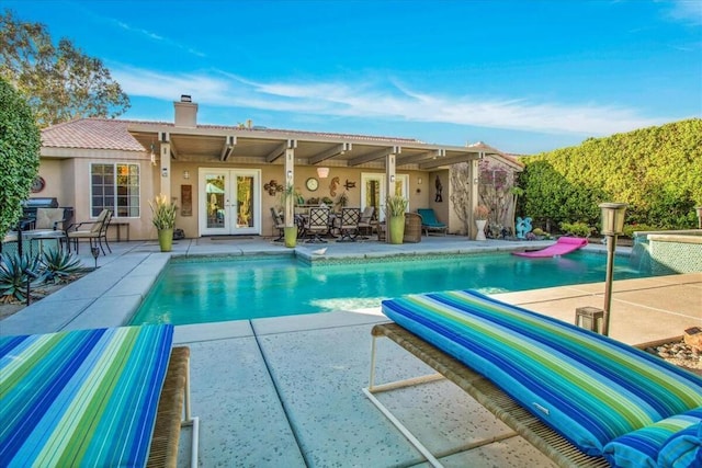 view of pool with a patio and french doors