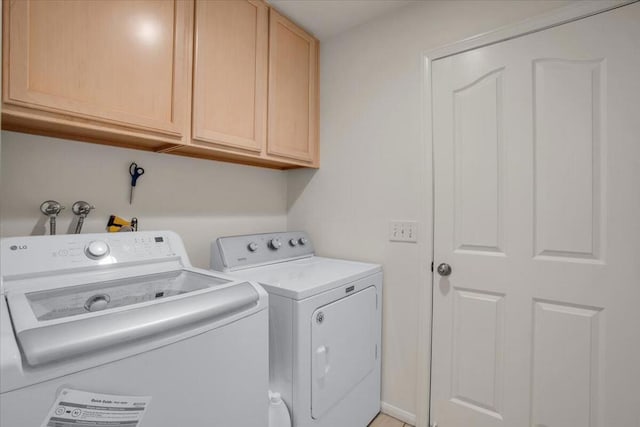 washroom featuring washer and clothes dryer and cabinets