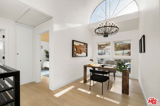 office space with a healthy amount of sunlight, light hardwood / wood-style flooring, and a chandelier