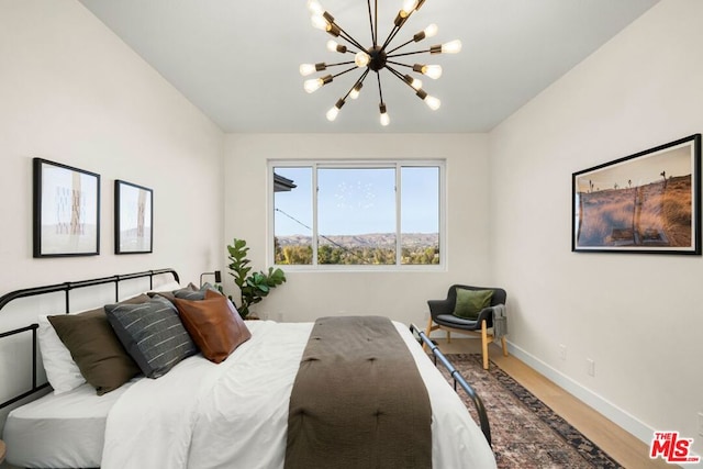 bedroom with an inviting chandelier and hardwood / wood-style floors