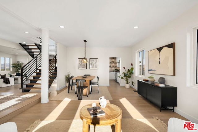 living room with light hardwood / wood-style floors and decorative columns