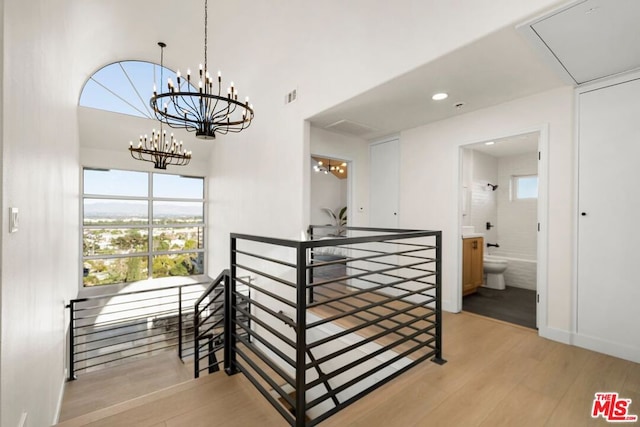 hallway featuring light hardwood / wood-style flooring and a chandelier