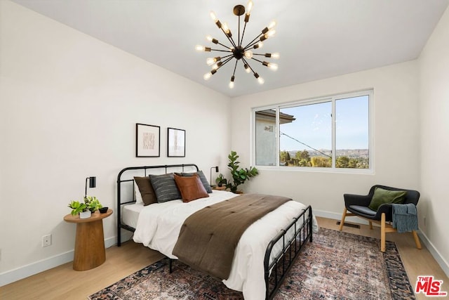 bedroom featuring a notable chandelier and hardwood / wood-style floors