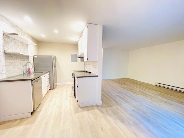 kitchen featuring stainless steel appliances, sink, light hardwood / wood-style flooring, white cabinetry, and tasteful backsplash