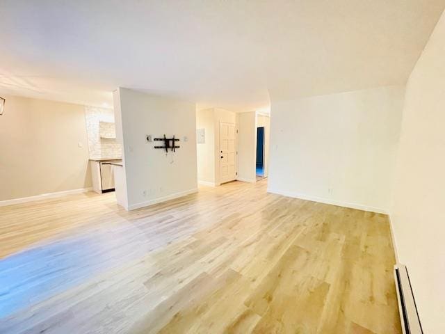 spare room with light wood-type flooring and a baseboard radiator