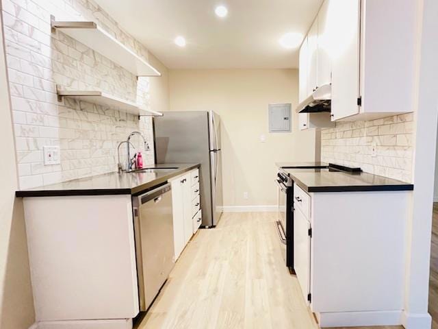 kitchen featuring light hardwood / wood-style floors, backsplash, white cabinets, appliances with stainless steel finishes, and sink