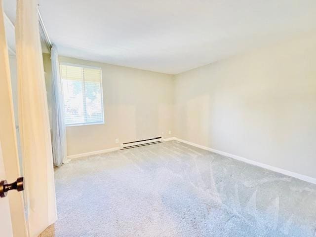 empty room with light colored carpet and a baseboard radiator