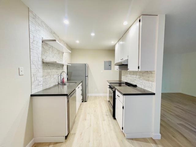 kitchen with appliances with stainless steel finishes, white cabinets, light hardwood / wood-style flooring, backsplash, and sink