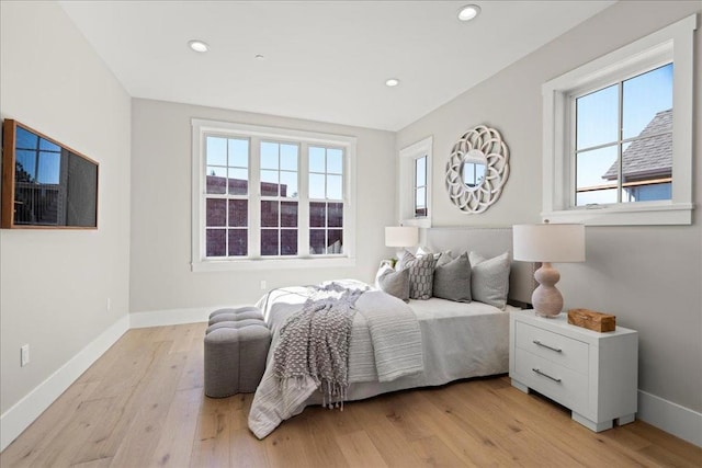 bedroom with light wood-type flooring and multiple windows