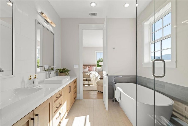 bathroom featuring a washtub, tile patterned floors, and vanity