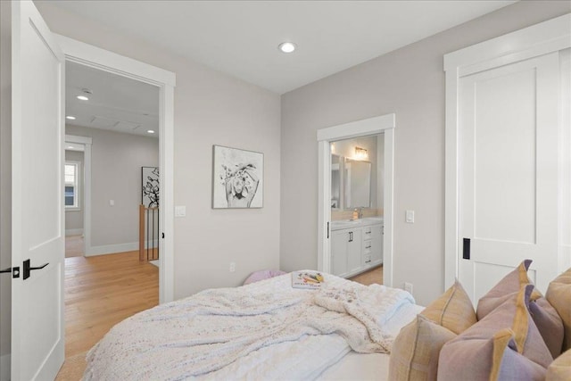 bedroom featuring light hardwood / wood-style flooring and ensuite bath