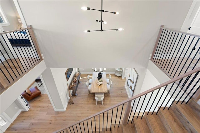 stairs with a chandelier and hardwood / wood-style floors