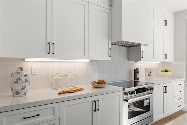 kitchen with white cabinetry, stainless steel electric stove, backsplash, and custom range hood