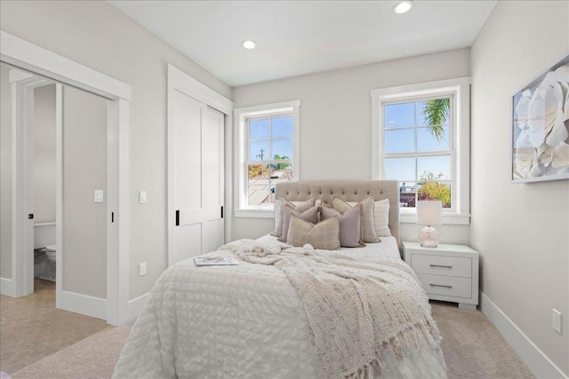 bedroom featuring light colored carpet and multiple windows