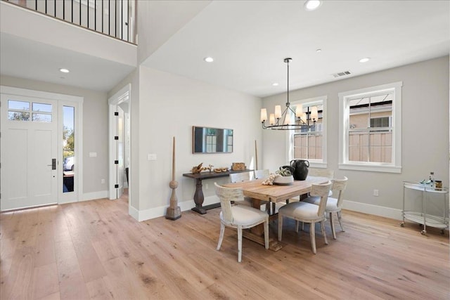 dining area featuring light wood-type flooring and an inviting chandelier