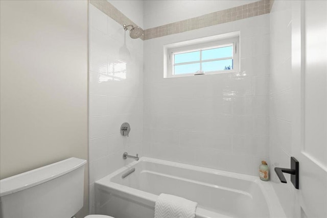 bathroom featuring tiled shower / bath combo and toilet