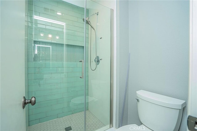 bathroom with toilet and an enclosed shower