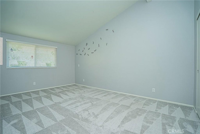 spare room with vaulted ceiling and carpet