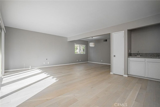 spare room with sink and light hardwood / wood-style flooring