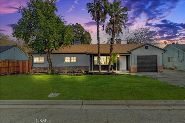 ranch-style home with a yard and a garage