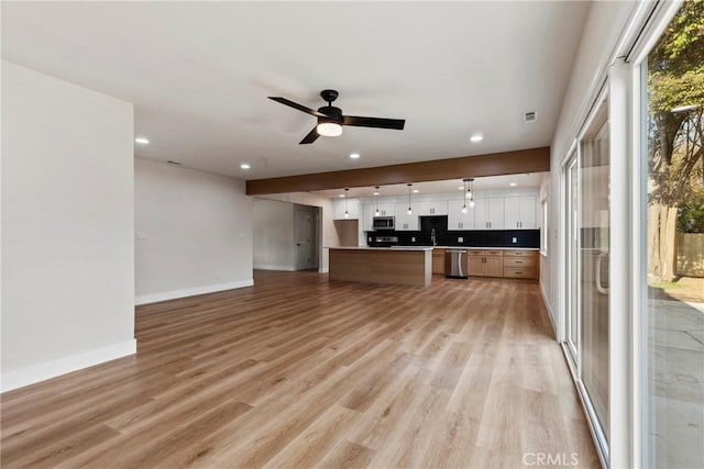 kitchen with white cabinetry, appliances with stainless steel finishes, ceiling fan, and light wood-type flooring