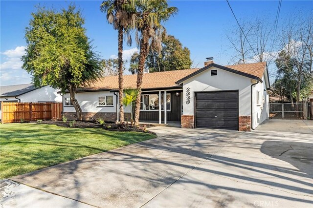 ranch-style house featuring a front yard and a garage