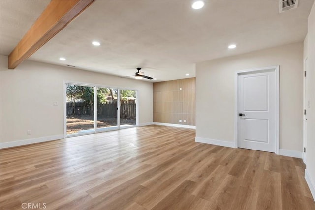 empty room featuring beam ceiling, light hardwood / wood-style floors, and ceiling fan