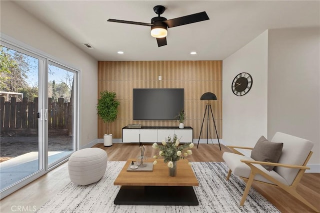 living room featuring light hardwood / wood-style floors and ceiling fan