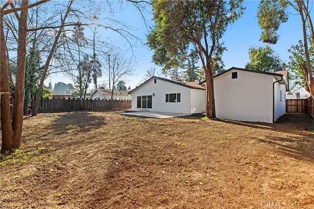 rear view of house with a patio and a yard