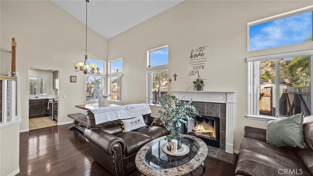 living room featuring an inviting chandelier, high vaulted ceiling, hardwood / wood-style floors, and a fireplace