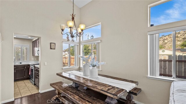 dining room with a towering ceiling, light hardwood / wood-style flooring, and a chandelier