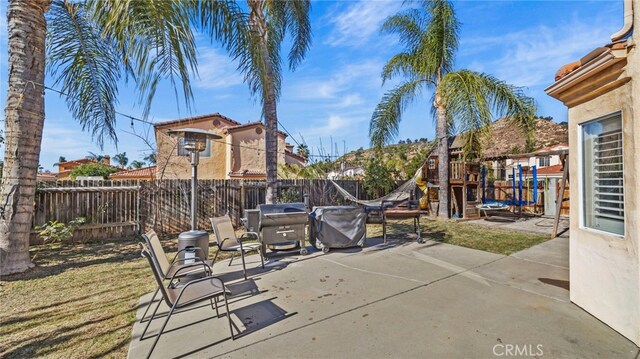 view of patio with grilling area and a playground