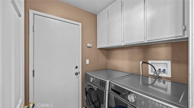 laundry room featuring washing machine and dryer and cabinets