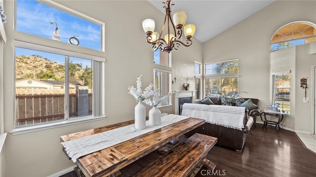 dining space featuring dark wood-type flooring, high vaulted ceiling, a notable chandelier, and a mountain view