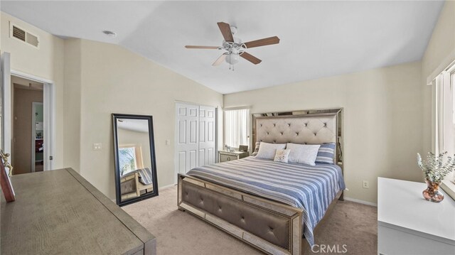 bedroom with a closet, ceiling fan, vaulted ceiling, and light colored carpet