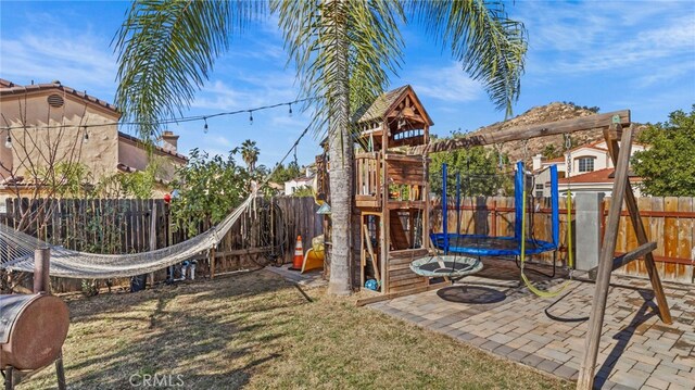 view of play area featuring a lawn and a trampoline