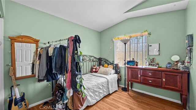 bedroom featuring vaulted ceiling and light hardwood / wood-style flooring