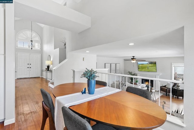 dining area with a high ceiling, hardwood / wood-style floors, and ceiling fan