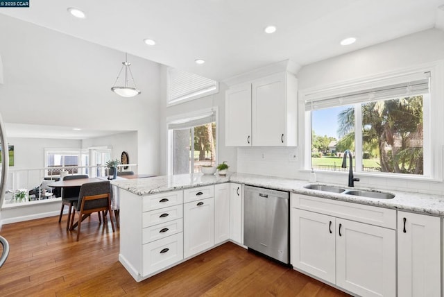 kitchen with sink, white cabinets, stainless steel dishwasher, hanging light fixtures, and plenty of natural light