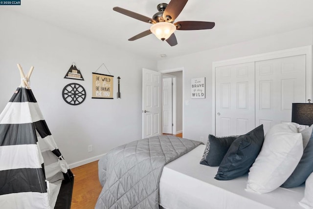 bedroom featuring ceiling fan, light hardwood / wood-style floors, and a closet