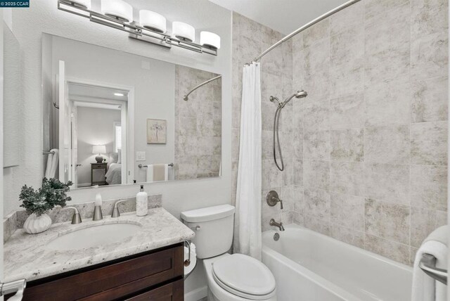 full bathroom with shower / bath combination with curtain, vanity, and toilet