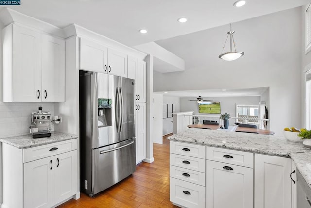 kitchen featuring hanging light fixtures, light hardwood / wood-style floors, stainless steel refrigerator with ice dispenser, white cabinets, and ceiling fan