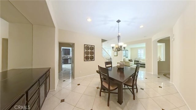 dining area with a chandelier and light tile patterned floors