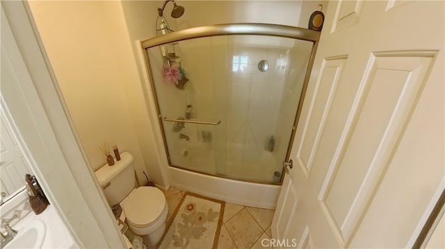 bathroom with toilet, shower / bath combination with glass door, and tile patterned floors