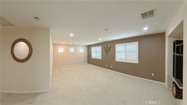 basement featuring light colored carpet and plenty of natural light