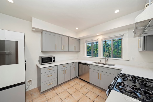 kitchen with exhaust hood, gray cabinets, appliances with stainless steel finishes, light tile patterned flooring, and sink