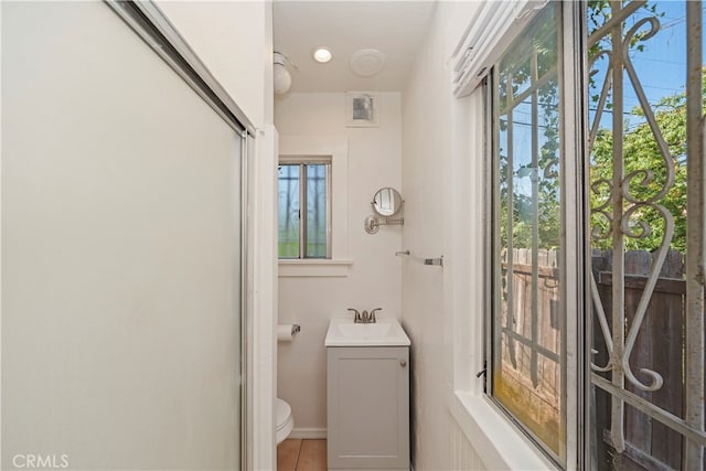 bathroom featuring vanity, plenty of natural light, and toilet